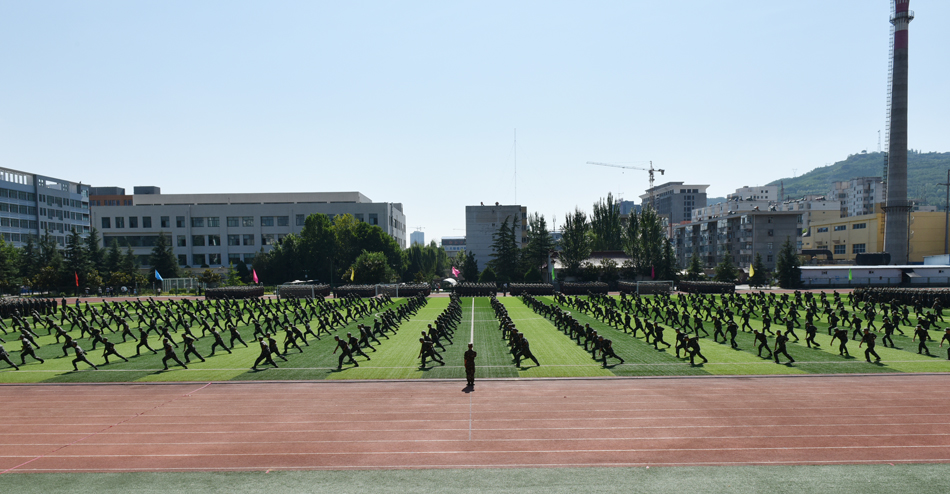 7月19日上午,天水师范学院2015级学生军训总结表彰大会在学校东田径场举行。96363部队副政委唐生奇上校,天水军分区综合办公室主任李天茂中校,96363部队政治部副主任、军训团团长王峰中校和校长蔡文浩、副校长安涛、副校长王旭林、党委副书记师平安、纪委书记李淳出席大会。大会由副校长汪聚应主持。 大会在雄壮的国歌声中拉开帷幕。 激昂的军乐声响起,分列式开始。各个方队喊着嘹亮的口号、迈着整齐的步伐依次从主席台前通过,接受学校领导的检阅。在随后的军事科目表演中,进行了队列队形示范、战术表演